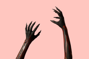 Black witch hands with claws on pink background. Halloween celebration © Pixel-Shot