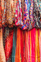 Colorful scarves for sale at an outdoor market.