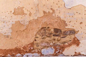 Peeling stucco on a rock wall.