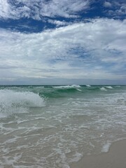 Large waves and fluffy white clouds over Gulf of Mexico Florida Emerald Coast 