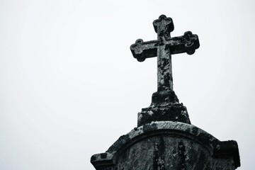 Solitary cross on weathered tombstone under twilight sky