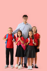 Fototapeta premium Male teacher with little pupils on pink background