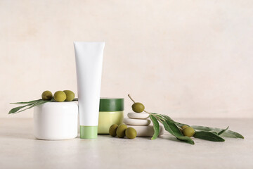 Set of natural cosmetic products, spa stones and green olives on light background