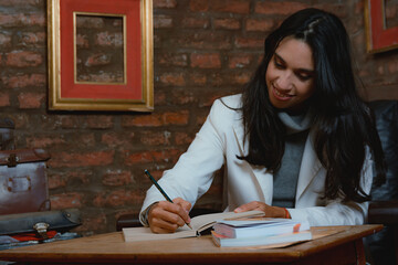 young female novelist writing a book in her office.