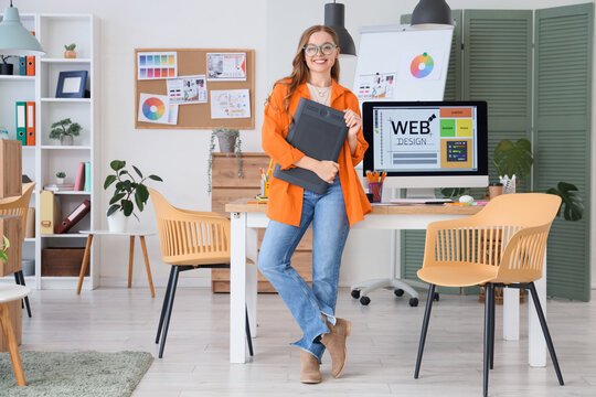 Female web designer with graphic tablet in office