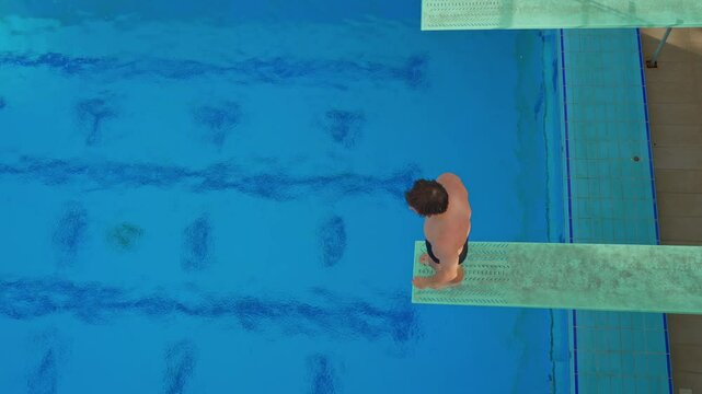 A professional athlete executes a flawless spring dive during a competition. The athlete's precision, strength, and grace are on full display, capturing the intensity and beauty of competitive diving