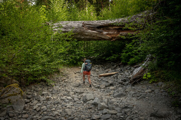 Obraz premium Woman Backpacks Along the Hogh River Trail Through Rocky Wash
