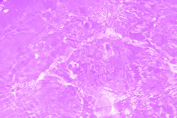 Pink water bubbles on the surface ripples. Defocus blurred transparent pink colored clear calm water surface texture with splash and bubbles. Water waves with shining pattern texture background
