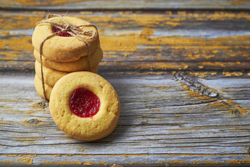 Stack of Jam-Filled Cookies Tied with Twine on Rustic Wooden Table