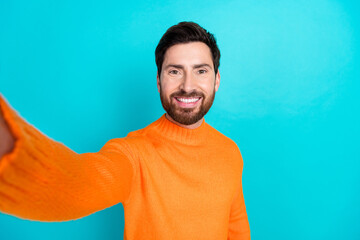 Fototapeta premium Photo of positive handsome man wear orange trendy clothes make selfie isolated on cyan color background