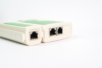 This is a green and white device with two network jacks. This tool is usually used to check LAN cables.