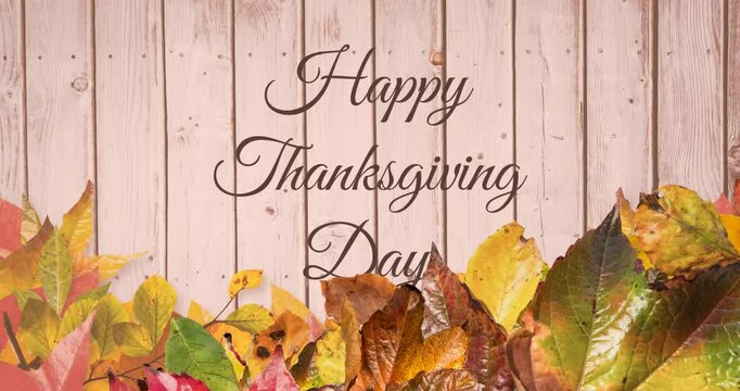 Animation of happy thanksgiving day text over autumn leaves wooden background
