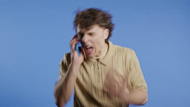 Angry handsome man quarreling, screaming talking on mobile phone. Guy in stress