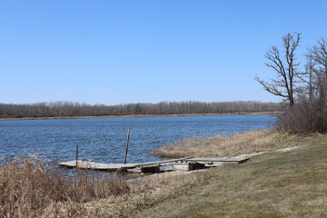 Fototapeta premium rustic wooden dock on a lake under blue skies