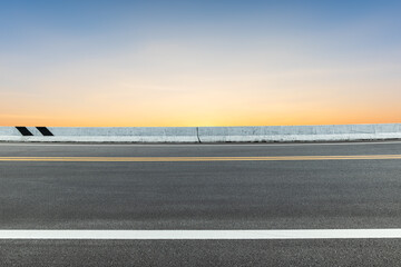 Fototapeta premium Side view of asphalt road with landscape of sunset sky.