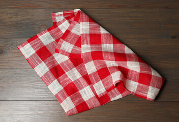 Crumpled tablecloth with checkered pattern on wooden table, top view