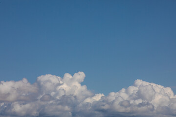 White and grayish cotton like clouds bottom layer of photo dead space of bright blue clear sky on top.Heavenly background.