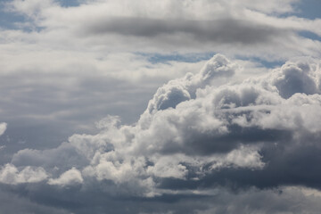 Photograph of white and grayish clouds covering the whole sky multiple types of clouds wispy thin and puffy overcast day.
