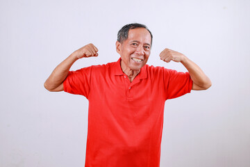 Fototapeta premium Healthy Asian old man raise two hands showing muscles isolated on white background