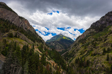 Photograph of stormy cloudy bright blue sky picking throw Abrams Mountain in Colorado near bear creek park. Vivid bright landscape photo.