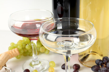 Wine in a glass with grapes on a light background.
