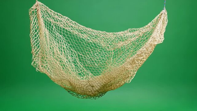 Empty fishing net hangs against a vibrant green screen, perfect for creative projects