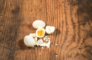 Peeled fresh organic eggs isolated on a rustic wooden table with advertising space.