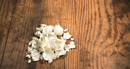 White egg shells isolated on a rustic wooden table with advertising space. 