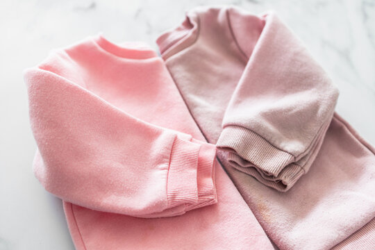 new vs old and used clothes, identical sweaters, side by side, unused vs worn out discoloured and shrunk