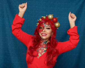 Woman with christmas makeup and christmas tree balls headband with joyful expression.