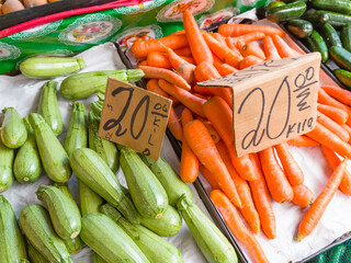 pile of carrots and zucchini at the market with price on a sign, market concept