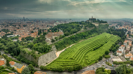 Aerial view of Brescia medieval castle, city center, city walls, bastions, vineyards in Lombardy Italy