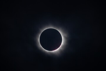 A stunning view of a solar eclipse, showcasing the dark silhouette of the moon completely covering the sun, with a halo of light around the edges.