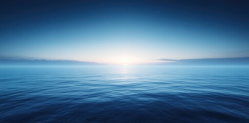 Fototapeta premium A Calm Sea Under a Blue Sky With a Distant Sunset