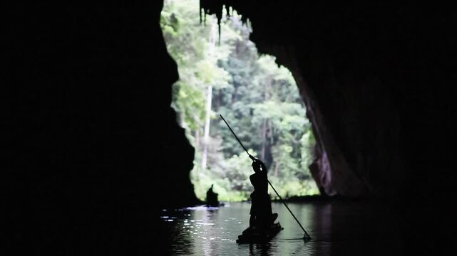 silhouette shot of rafting in the huge cave by the small bamboo raft. It's one of the famous attractive tourist site in Mae Hong son,Thailand.