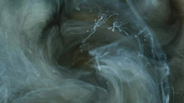 Glitter mist swirl. Ink splash water. Defocused blue golden color shimmering particles texture fume whirl flow motion abstract art background.