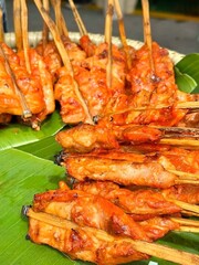 Grilled chicken with bamboo skewers on babana leaves, street food in Thailand