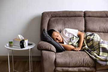 Tired Peaceful Asian Man Sleeping On Soft Pillow Under Blanket On Couch At Home