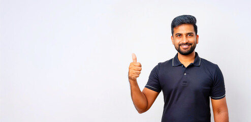 A portrait of a South Asian man in a black polo shirt giving a thumbs up.