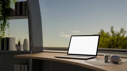 Fototapeta premium A laptop mockup on a table in modern room, positioned against a large window with a view of the sky