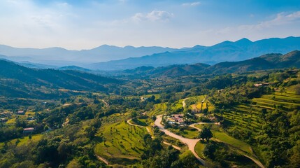 Panoramic view of a lush green valley surrounded by majestic mountains under a vibrant summer sky