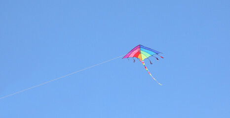 kite that flies alone like many colors in the sky and the string that holds it symbol of childhood and lightheartedness