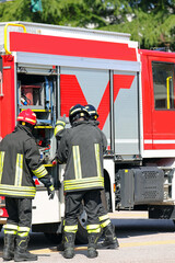 firefighters take specialized rescue equipment from red fire engine