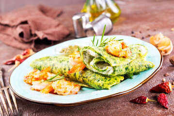 Green pancakes close-up with shrimps stuffing and cheese