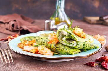 Green pancakes close-up with shrimps stuffing and cheese