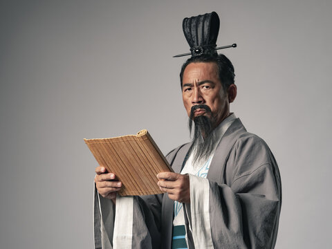 三国志に登場するような中国歴史上の偉人が竹簡の文書を読むシーン