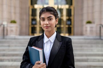 Young Indian female law student with formal attire holding law book