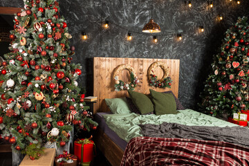 double bed stands in the bedchamber with decorated new year tree