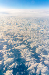 View from the airplane window at a beautiful cloudy sky and the airplane wing