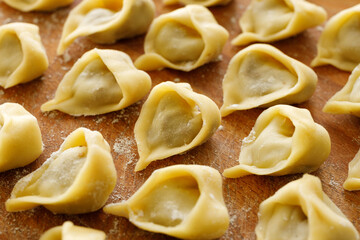 Raw homemade mushroom dumplings, uszka traditionally served with red borscht for Christmas Eve, focus on dumpling in the middle,  close up view